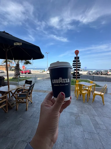 Taza de café frente a la terraza y el mar de Arica