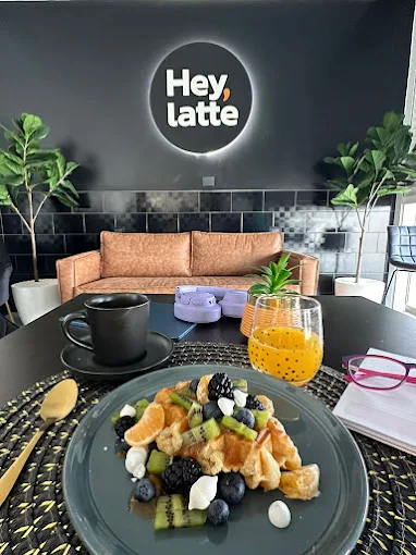 Desayuno con fruta y café en el interior de Hey, latte