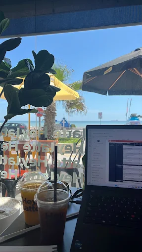 Personas trabajando con vista al mar desde Hey, latte